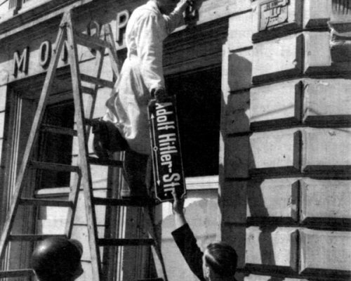 Adolf-Hitler-Straßenschild wird abmontiert, 1945